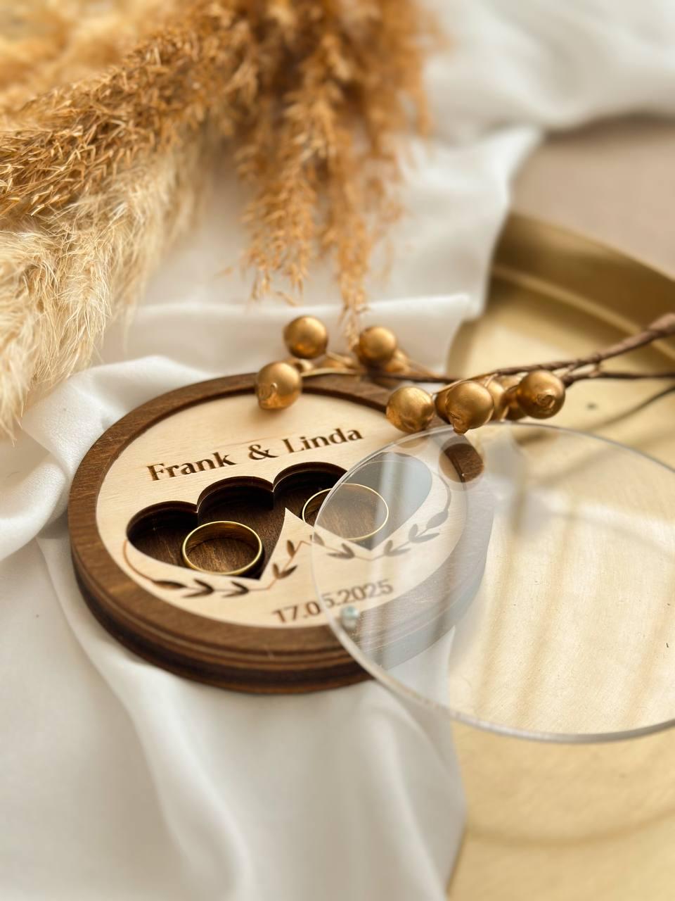 Round wooden wedding ring box open showing velvet interior
